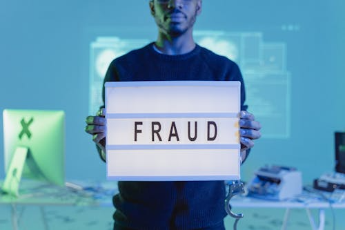 A person holding a fraud sign