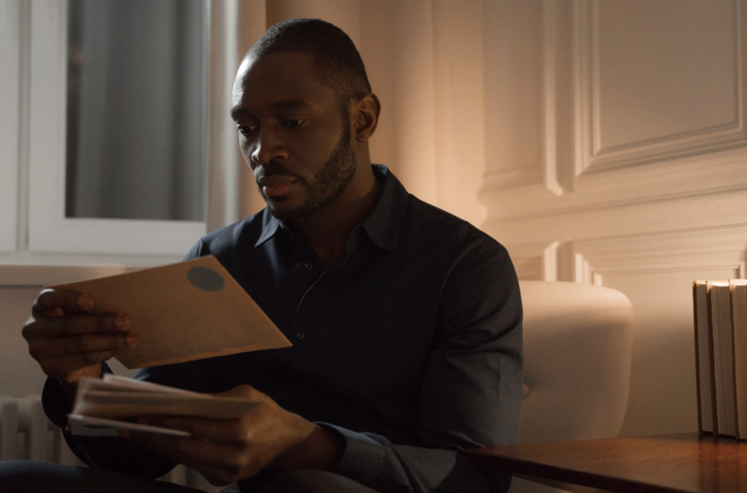This photo shows a person holding a paper letter and unopened envelopes.