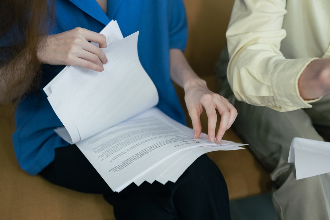 A person reviewing paperwork and documents at a desk.